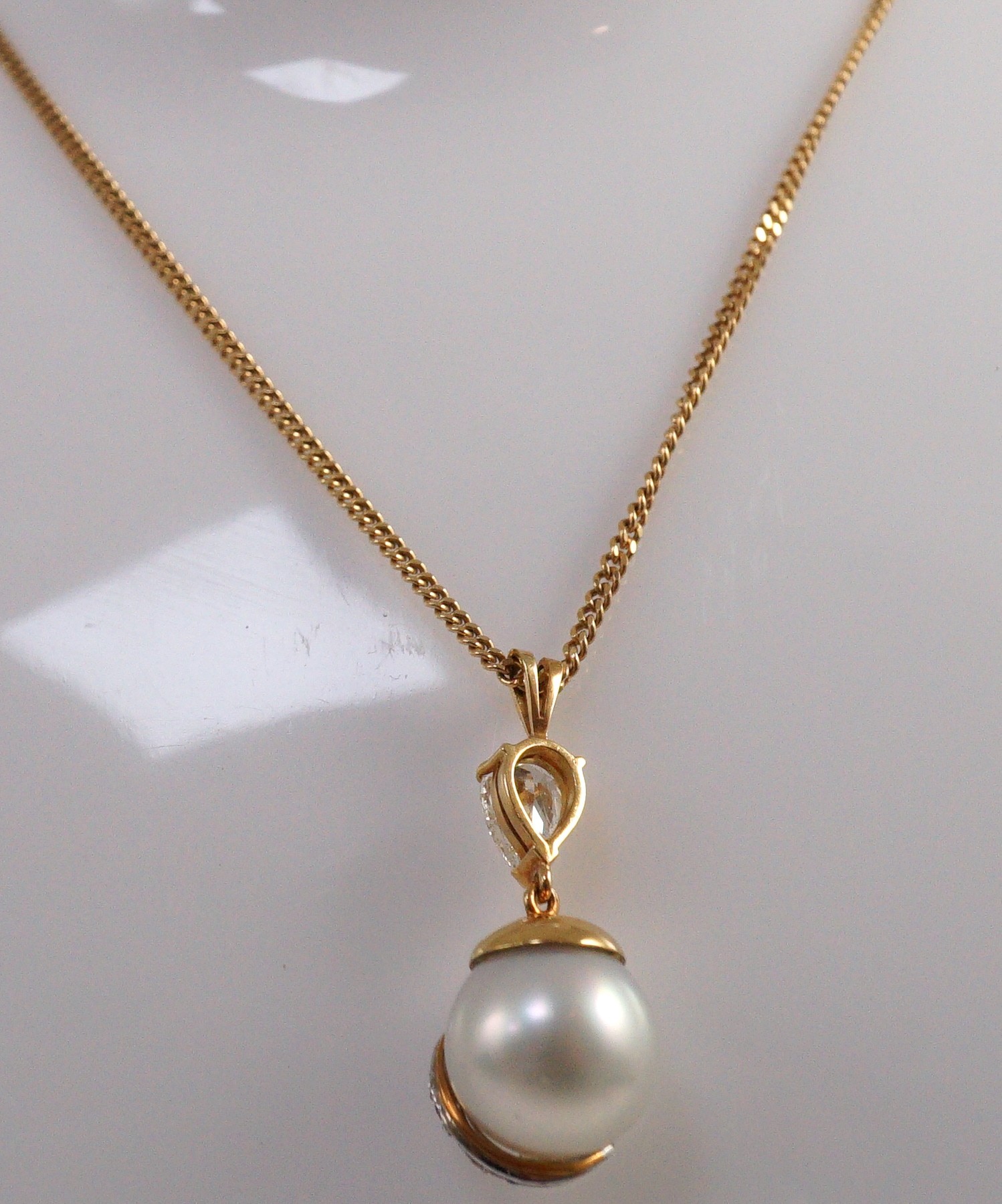 A modern gold, single stone South Sea pearl, single stone pear cut diamond and graduated seven stone pink diamond set drop pendant